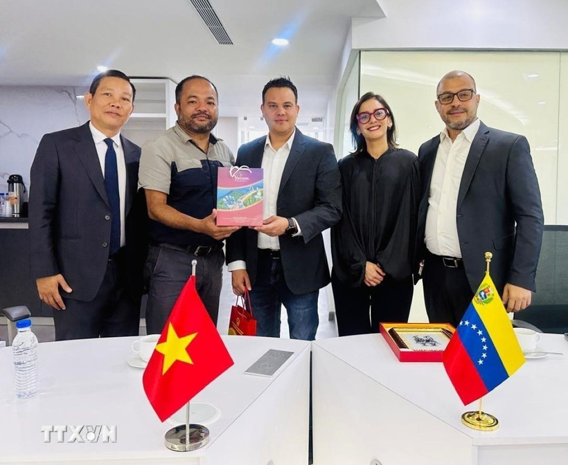 Trưởng Cơ quan thường trú TTXVN tại Mexico Trương Phi Hùng tặng quà lưu niệm cho Thứ trưởng Bộ Thông tin Truyền thông Venezuela Simón Arrechide. (Ảnh: AVN/TTXVN phát) 