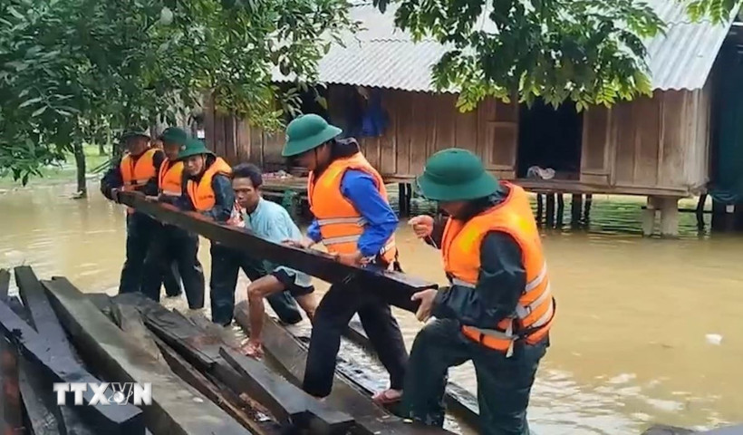 Đồn Biên phòng Làng Ho (Bộ đội Biên phòng Quảng Bình) hỗ trợ các hộ dân ứng phó mưa bão. (Ảnh: TTXVN phát)