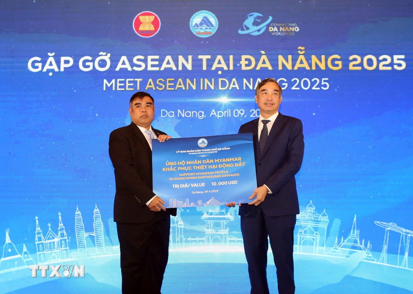 Chủ tịch Uỷ ban Nhân dân thành phố Đà Nẵng Lê Trung Chinh (phải) trao bảng tượng trưng số tiền ủng hộ khắc phục hậu quả động đất cho Đại biện lâm thời Myanmar tại Việt Nam. (Ảnh: Trần Lê Lâm/TTXVN)