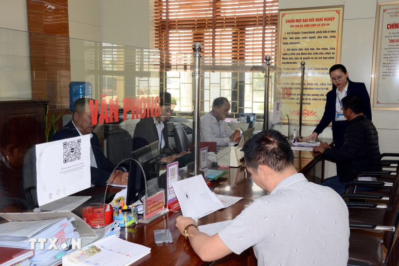Người dân đến thực hiện các thủ tục hành chính tại bộ phận một cửa của xã được cán bộ, công chức hướng dẫn tận tình. (Ảnh: Thanh Vân/TTXVN)