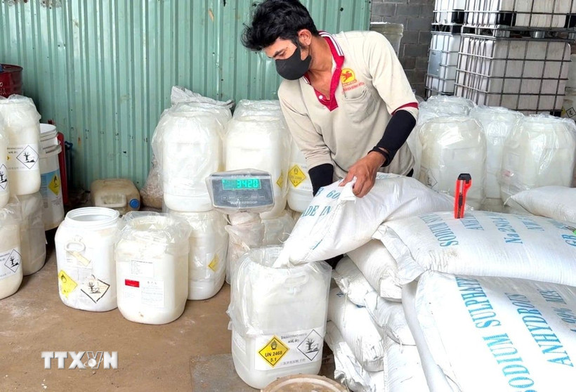 Công nhân trộn và đóng gói sản phẩm từ các nguyên liệu có nguồn gốc xuất xứ nước ngoài rồi dán tem, nhãn. (Ảnh: TTXVN phát)