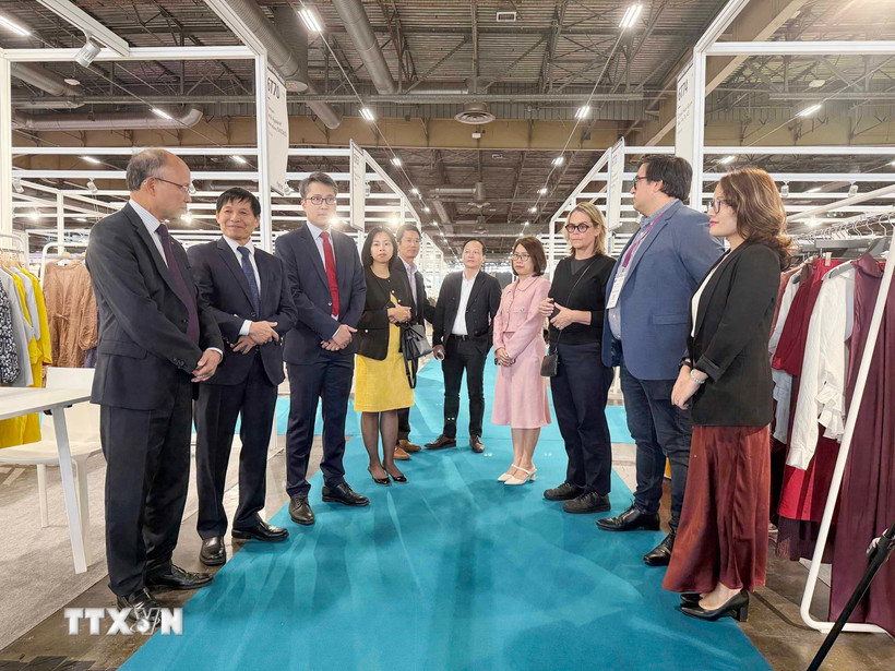 Đại sứ Việt Nam tại Pháp Đinh Toàn Thắng, đại diện Ban tổ chức và các đơn vị hỗ trợ trao đổi với các doanh nghiệp Việt Nam tham dự Triển lãm. (Ảnh: Hữu Chiến/TTXVN)