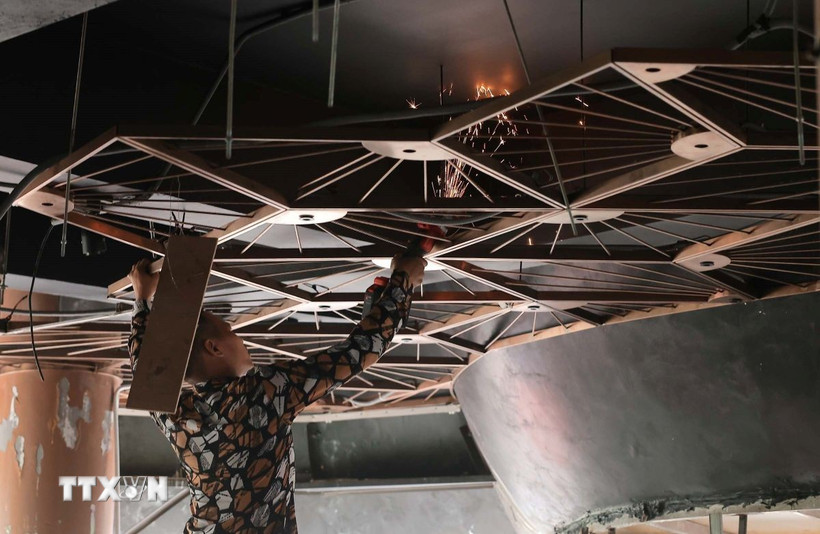 Công nhân tiến hành tháo dỡ các trang thiết bị bên trong tòa nhà "Hàm cá mập". (Ảnh: Hoàng Hiếu/TTXVN)