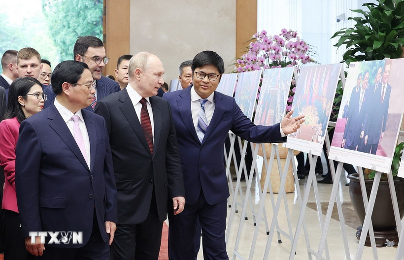 Thủ tướng Phạm Minh Chính và Tổng thống Liên bang Nga Vladimir Putin xem trưng bày ảnh về quan hệ hợp tác giữa hai nước do Thông tấn xã Việt Nam thực hiện. (Ảnh: Dương Giang/TTXVN)