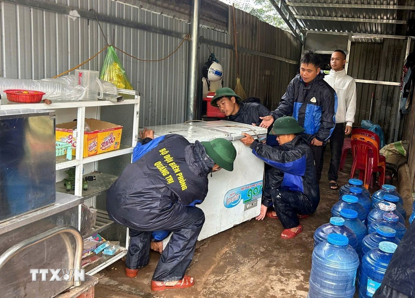 Tại Quảng Tri, bão số 10 gây thiệt hại nặng nề. Trong ảnh: Bộ đội Biên phòng Quảng Trị hỗ trợ người dân di dời tài sản đến nơi an toàn. (Ảnh: TTXVN phát)