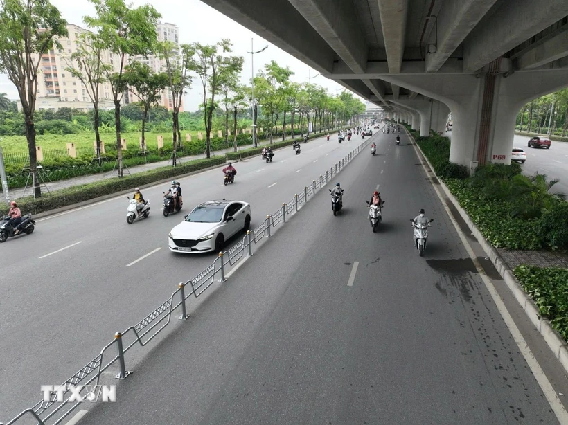 Xây dựng và triển khai phương án phân làn bằng dải phân cách cứng trên đường Phạm Văn Đồng. (Ảnh: Nguyễn Thắng/TTXVN)