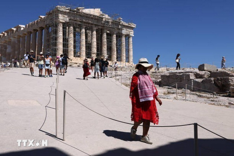 Người dân di chuyển dưới trời nắng nóng tại Athens, Hy lạp hồi tháng 7/2024. (Ảnh: Getty Images/TTXVN)