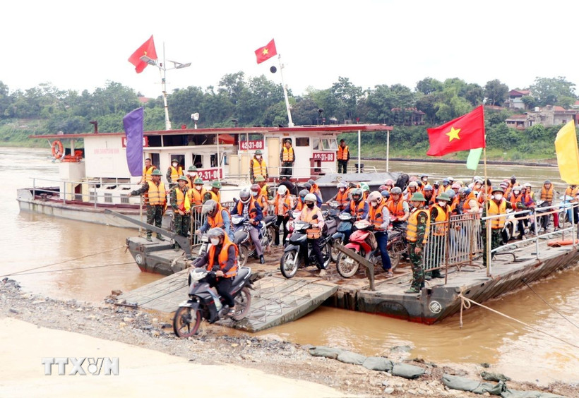 Người dân di chuyển qua sông tại Phú Thọ. (Ảnh: Tạ Toàn/TTXVN)