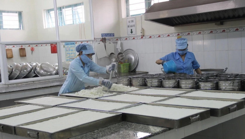 Nhân viên của bếp ăn của một trường học đảm bảo các quy chuẩn về vệ sinh an toàn thực phẩm. (Ảnh: TTXVN/Vietnam+)