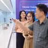 Lãnh đạo Cục Quản lý và Phát triển thị trường trong nước hướng dẫn nhận biết hàng không chính hãng. (Ảnh: PV/Vietnam+)