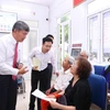 Chủ tịch Ủy ban Nhân dân phường Hồng Hà trao đổi với người dân đến làm thủ tục hành chính tại Điểm số 1-Khu vực Tứ Liên. (Ảnh: Xuân Quảng/Vietnam+)