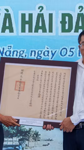 Ông Mai Văn Khôi đại diện Tộc Mai Văn hiến tặng 07 sắc bằng liên quan đến thủy quân triều Nguyễn cho Nhà Trưng bày Hoàng Sa. (Ảnh: Thanh Phong/Vietnam+)