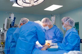 Các bác sỹ thực hiện ca phẫu thuật cho trẻ. (Ảnh: PV/Vietnam+)