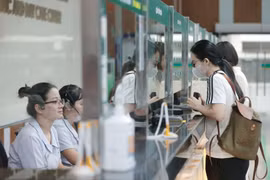 Người dân đến khám bệnh đăng ký tại quầy tiếp đón. (Ảnh: Minh Quyết/TTXVN)