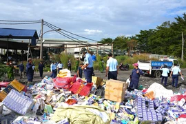 Lực lượng chức năng tỉnh Tây Ninh tổ chức tiêu hủy trên 62 nghìn bao thuốc lá nhập lậu. (Ảnh: TTXVN/Vietnam+) 