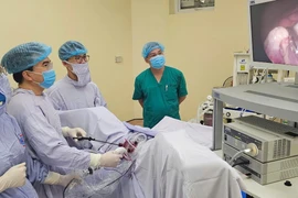 Các bác sỹ thực hiện ca phẫu thuật nội soi cho bệnh nhân. (Ảnh: PV/Vietnam+)