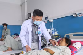 Bác sĩ Bệnh viện Bệnh Nhiệt đới Thành phố Hồ Chí Minh thăm khám cho bệnh nhân mắc sởi. (Ảnh: Đinh Hằng/TTXVN)