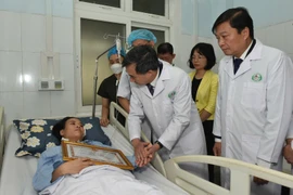 Thứ trưởng Bộ Y tế Trần Văn Thuấn thăm hỏi nhân viên bị thương. (Ảnh: PV/Vietnam+)