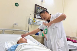 Bác sỹ theo dõi, kiểm tra sức khỏe của bệnh nhân sau phẫu thuật. (Ảnh: PV/Vietnam+)