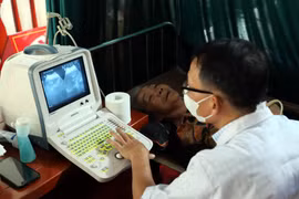 Bác sỹ siêu âm cho người dân trong một chương trình khám sàng lọc miễn phí. (Ảnh: TTXVN/Vietnam+)