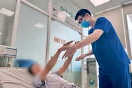 Bác sỹ Bệnh viện Bệnh Nhiệt đới Trung ương theo dõi sức khỏe cho bệnh nhân. (Ảnh: PV/Vietnam+)