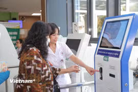 Người bệnh làm thủ tục ở ki-ốt đăng ký khám tự động tại Bệnh viện Đa khoa Đức Giang. (Ảnh: PV/Vietnam+)