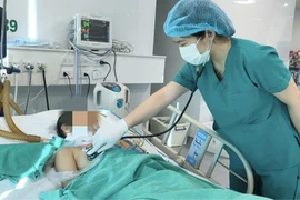 Bác sỹ thăm khám cho bệnh nhân. (Ảnh: PV/Vietnam+)