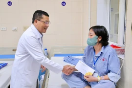 Lãnh đạo Bệnh viện K trao quà hỗ trợ cho bệnh nhân ung thư. (Ảnh: PV/Vietnam+)