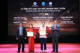 Ban Tổ chức trao chứng nhận và hoa cho các tác giả đoạt giải. (Ảnh: PV/Vietnam+)
