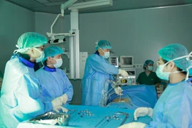 Phó giáo sư Nguyễn Lê Bảo Tiến thực hiện ca phẫu thuật cột sống. (Ảnh: PV/Vietnam+)