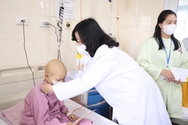 Bộ trưởng Bộ Y tế đã thăm hỏi sức khỏe các bệnh nhi. (Ảnh: PV/Vietnam+)