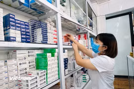 Lấy thuốc chữa bệnh tại một cơ sở y tế. (Ảnh: T.G/Vietnam+)