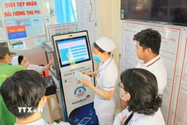 Người bệnh thực hiện đăng ký khám chữa bệnh bằng ki-ốt thông minh tại trung tâm y tế An Phú, An Giang. (Ảnh: Công Mạo/TTXVN)