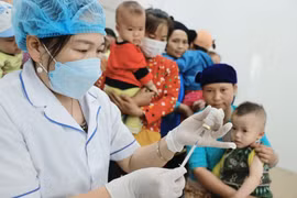 Người dân đưa trẻ đến tiêm chủng. (Ảnh: Minh Quyết/TTXVN)