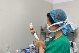 Bác sỹ của Bệnh viện Phụ sản-Nhi Đà Nẵng chuẩn bị thuốc để tiêm cho bệnh nhân. (Ảnh: PV/Vietnam+)