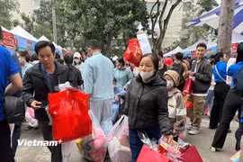 Gia đình các bệnh nhân nhi với những túi quà đầy đủ các mặt hàng phục vụ Tết. (Ảnh: PV/Vietnam+)