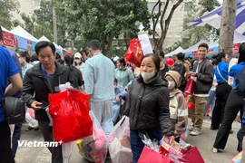 Gia đình các bệnh nhân nhi với những túi quà đầy đủ các mặt hàng phục vụ Tết. (Ảnh: PV/Vietnam+)