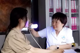 Phó giáo sư Đỗ Thị Thu Hiền khám cho bệnh nhân bị bệnh bạch biến. (Ảnh: PV/Vietnam+)