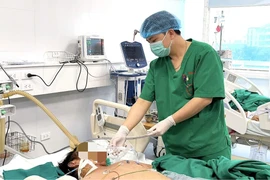 Các bác sỹ theo dõi sức khỏe cho bệnh nhân. (Ảnh: PV/Vietnam+)