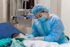 Nhân viên y tế theo dõi sức khoẻ của bệnh nhi sau ghép gan. (Ảnh: PV/Vietnam+)