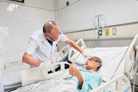 Bác sỹ kiểm tra tình trạng của bệnh nhân sau phẫu thuật. (Ảnh: PV/Vietnam+)