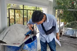 Kiểm tra các thùng phuy chứa nước trong gia đình, môi trường muỗi sinh sản loăng quăng. (Ảnh: TTXVN)
