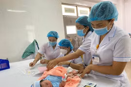 Nhân viên y tế thực hiện sàng lọc các bệnh ở trẻ sau sinh. (Ảnh: PV/Vietnam+)