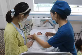 Căn cứ điều kiện kinh tế-xã hội và khả năng cân đối ngân sách nhà nước, các tỉnh, thành phố có chính sách hỗ trợ cặp vợ chồng, cá nhân sinh con, nuôi con. (Ảnh: TTXVN)