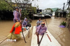 Cán bộ chiến sỹ giúp người dân dọn dẹp khắc phục hậu quả lũ lụt. (Ảnh: Danh Lam/TTXVN)