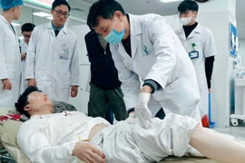 Các bác sỹ Bệnh viện Hữu nghị Việt Đức kiểm tra tình trạng cho các bệnh nhân. (Ảnh: PV/Vietnam+)