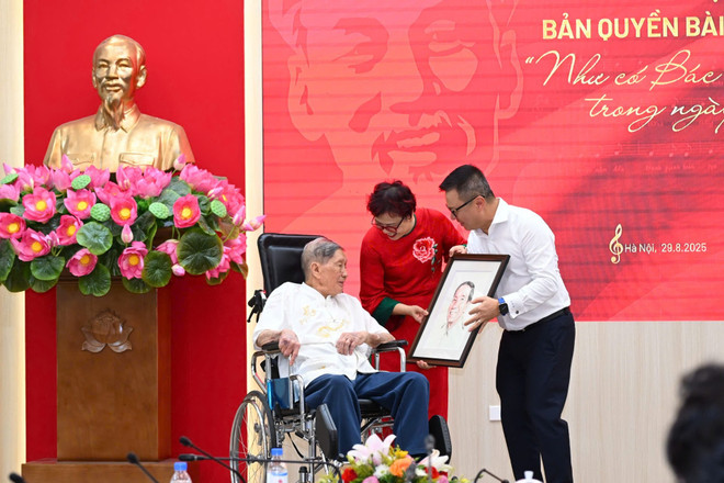 លោក Le Quoc Minh ជូនតន្ត្រីករ Pham Tuyen ជាមួយរូបគំនូរ។ (រូបថត៖ CTV/Vietnam+) nhac-si-pham-tuyen-nhu-co-bac-trong-ngay-dai-thang-5-1557.jpg
