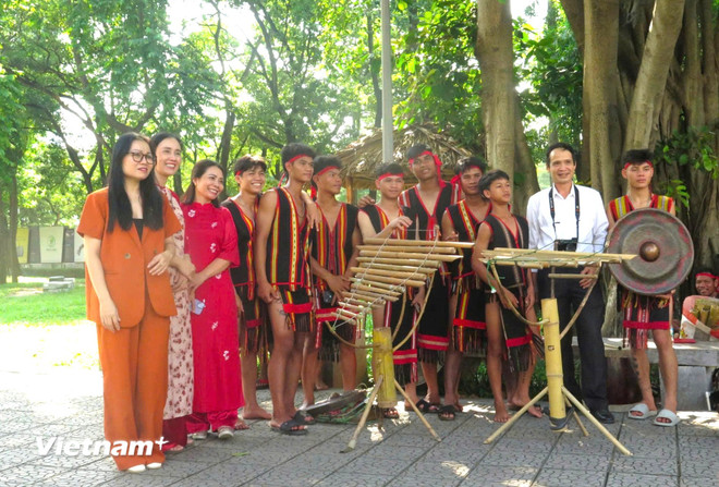Artizanii gong Quang Ngai fac fotografii suvenir cu vizitatorii și cercetătorii în spațiul expozițional în aer liber al Muzeului de Etnologie din Vietnam. (Foto: PV/Vietnam+) vnp-dantoc-2.jpg