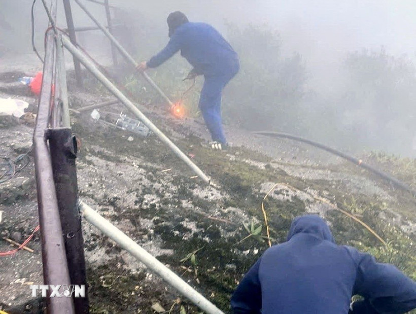 Lực lượng chức năng triển khai lắp đặt lan can ở khu vực nguy hiểm. (Ảnh: TTXVN phát)