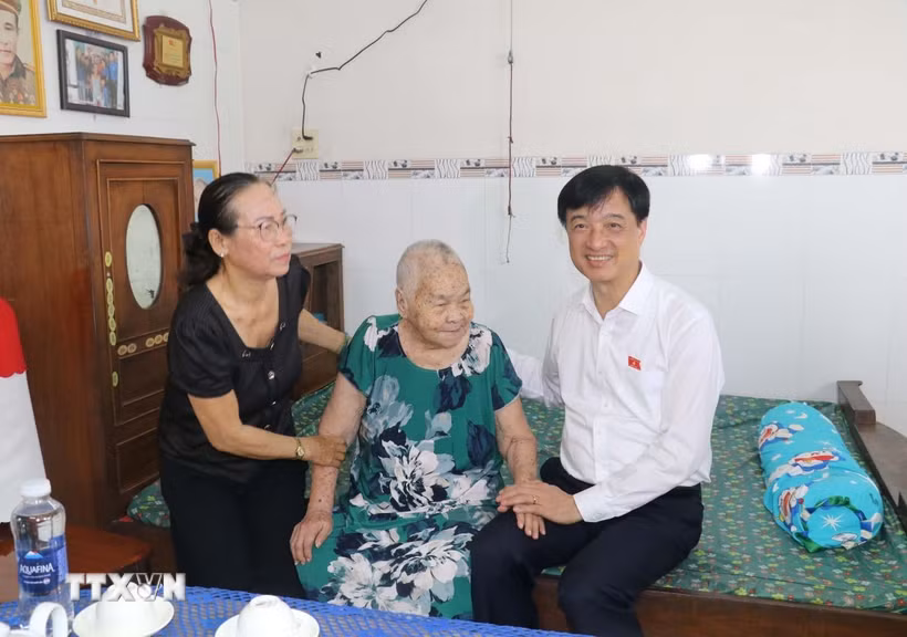 Trưởng ban Tổ chức Trung ương Nguyễn Duy Ngọc thăm, tặng quà gia đình Mẹ Việt Nam anh hùng Huỳnh Thị Lành, 94 tuổi đời, 58 năm tuổi Đảng, có chồng là Anh hùng Lực lượng vũ trang nhân dân Nguyễn Hữu Cầu, có 2 con là Liệt sỹ; ngụ tại phường An Bình. (Ảnh: Ngọc Thiện/TTXVN)